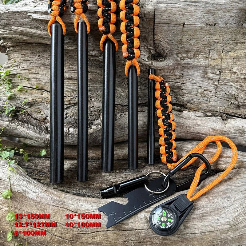 Black fire starters with orange paracord on a wooden surface, accompanied by a ruler for size reference.